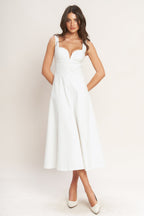 A solid white woven midi dress featuring sweetheart neckline, sleeveless, circle skirt and back zipper closure.