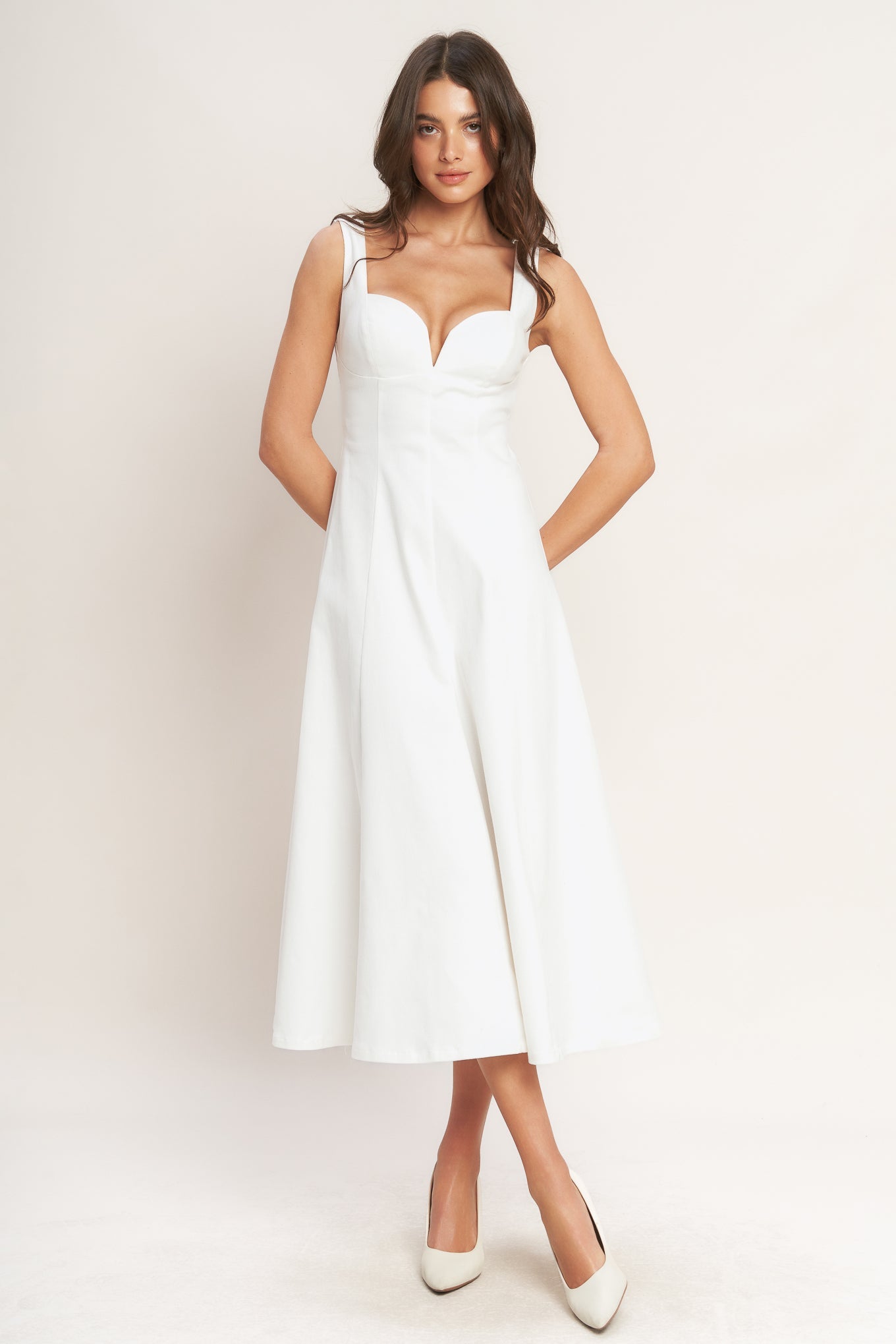 A solid white woven midi dress featuring sweetheart neckline, sleeveless, circle skirt and back zipper closure.