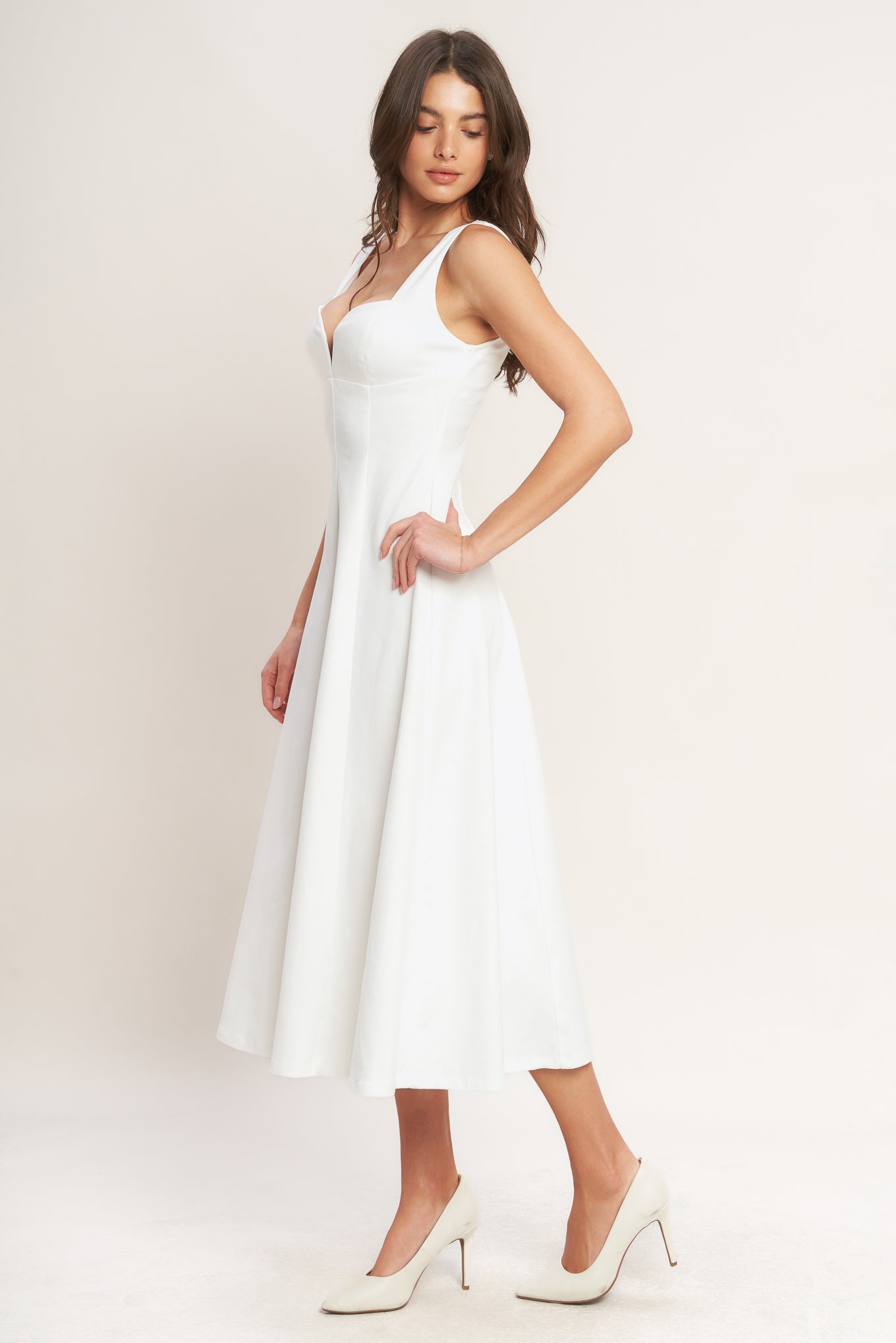 A solid white woven midi dress featuring sweetheart neckline, sleeveless, circle skirt and back zipper closure.