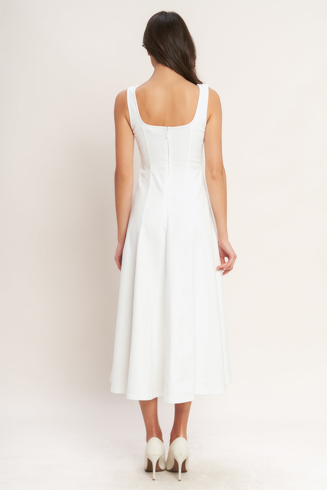 A solid white woven midi dress featuring sweetheart neckline, sleeveless, circle skirt and back zipper closure.