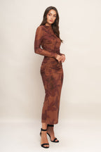 A printed power mesh midi dress featuring long sleeve, side shirring and back zipper closure