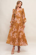 A brown, floral printed woven ankle dress featuring sweetheart neckline, long sleeve with smocked cuff, circle skirt and back zipper closure.