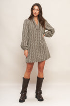 A textured woven mini dress featuring ruffled high neck with V front neckline and long sleeve