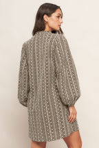 A textured woven mini dress featuring ruffled high neck with V front neckline and long sleeve