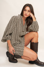 A textured woven mini dress featuring ruffled high neck with V front neckline and long sleeve