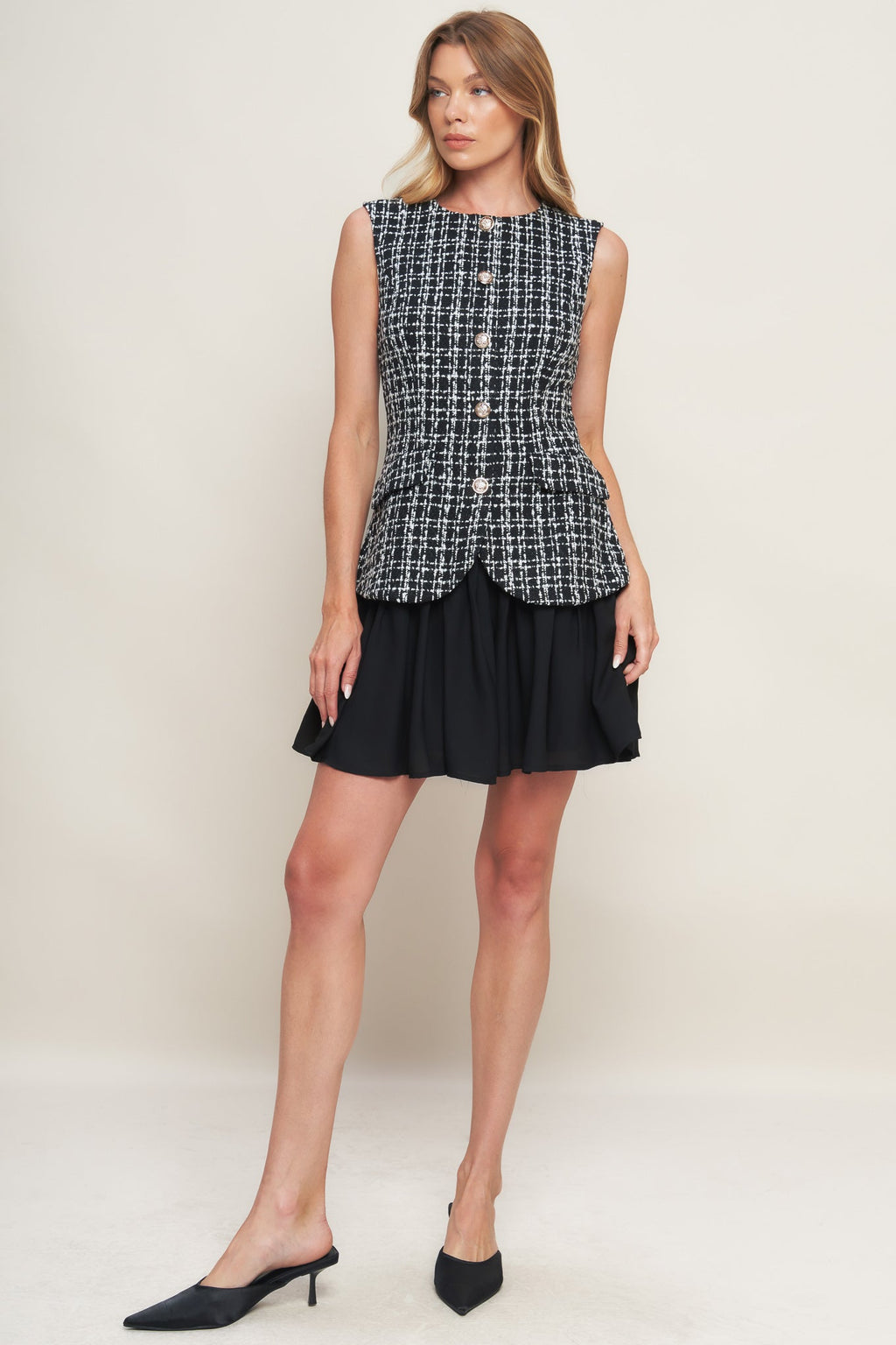 A tweed and solid woven mini dress featuring round neckline, sleeveless, front button down and flowy solid skirt.
