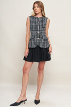 A tweed and solid woven mini dress featuring round neckline, sleeveless, front button down and flowy solid skirt.