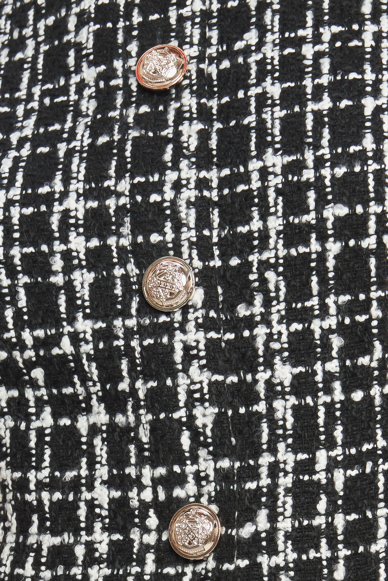 A tweed and solid woven mini dress featuring round neckline, sleeveless, front button down and flowy solid skirt.