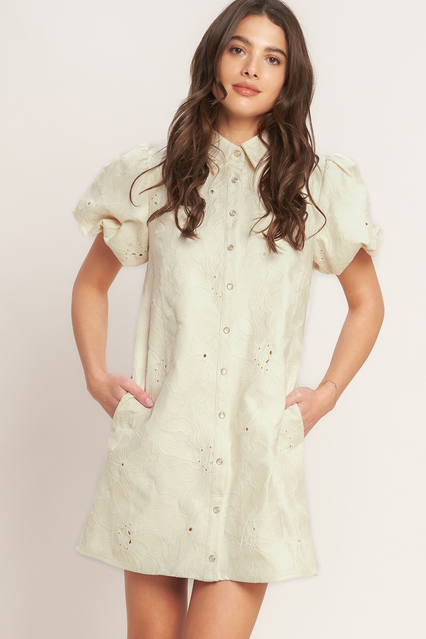 A floral textured woven mini dress featuring collar, short puff short and front button-down closure