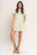 A floral textured woven mini dress featuring collar, short puff short and front button-down closure