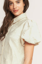 A floral textured woven mini dress featuring collar, short puff short and front button-down closure