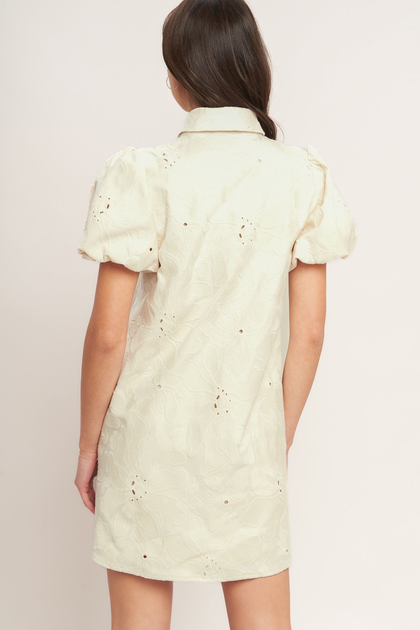 A floral textured woven mini dress featuring collar, short puff short and front button-down closure