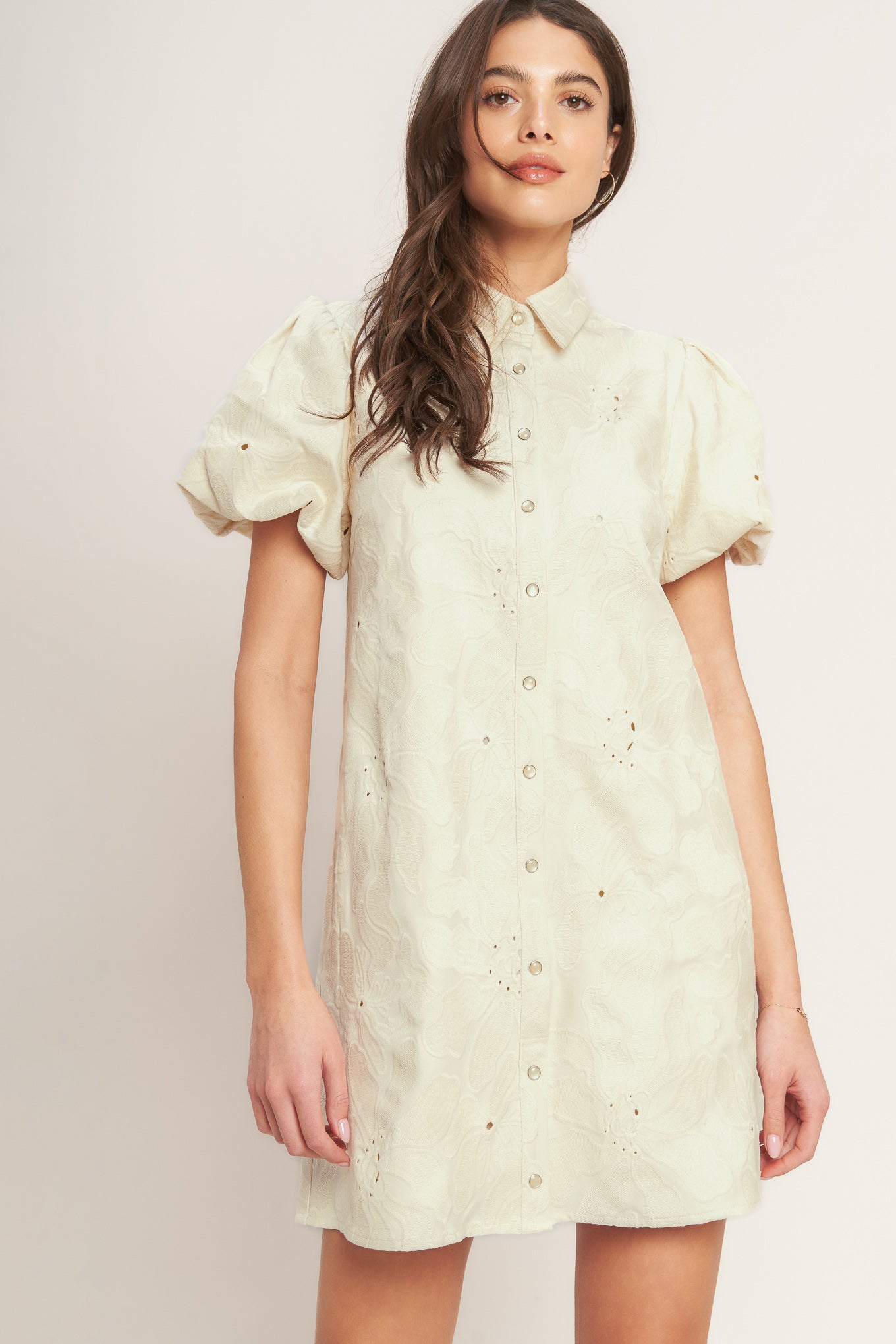 A floral textured woven mini dress featuring collar, short puff short and front button-down closure