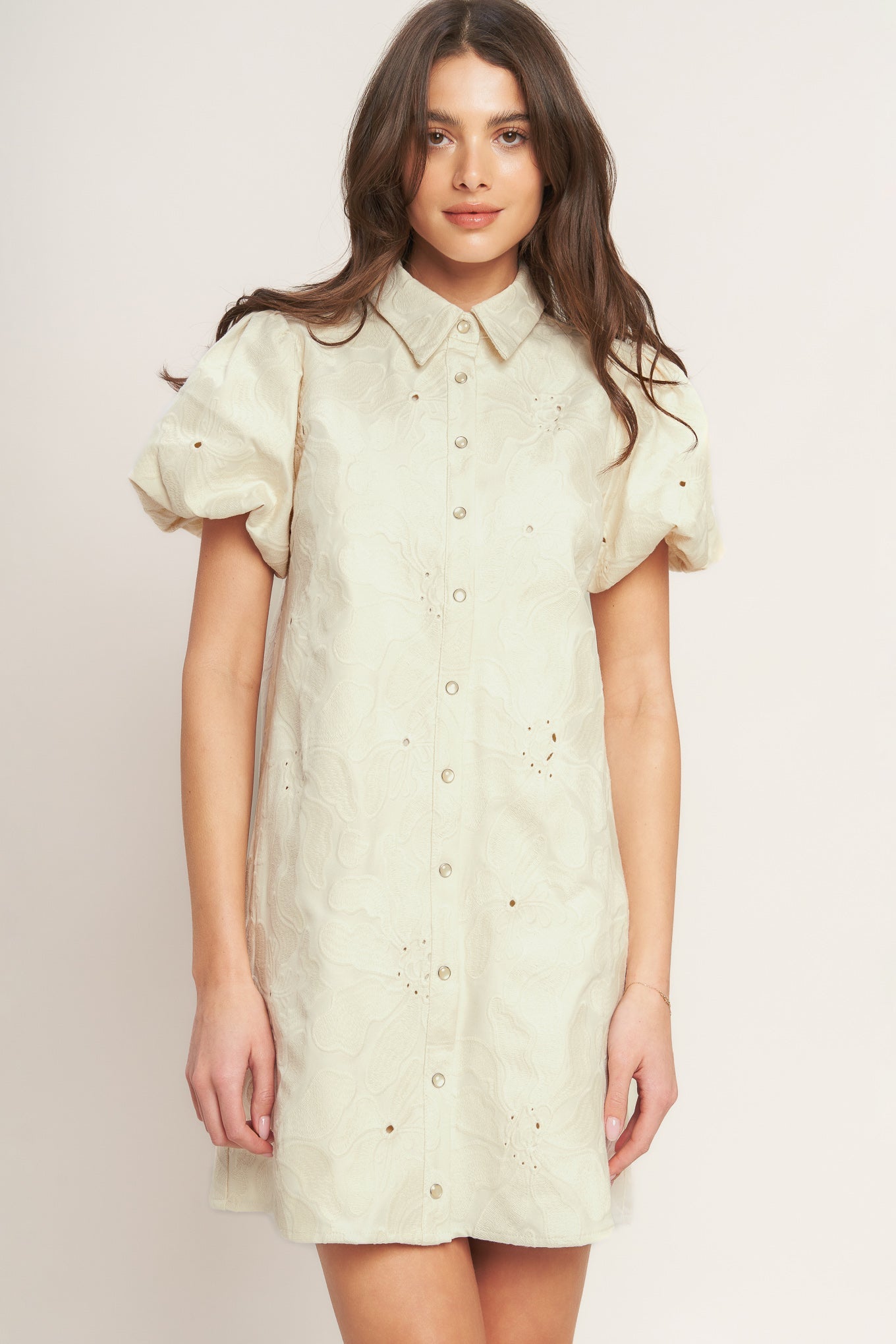 A floral textured woven mini dress featuring collar, short puff short and front button-down closure