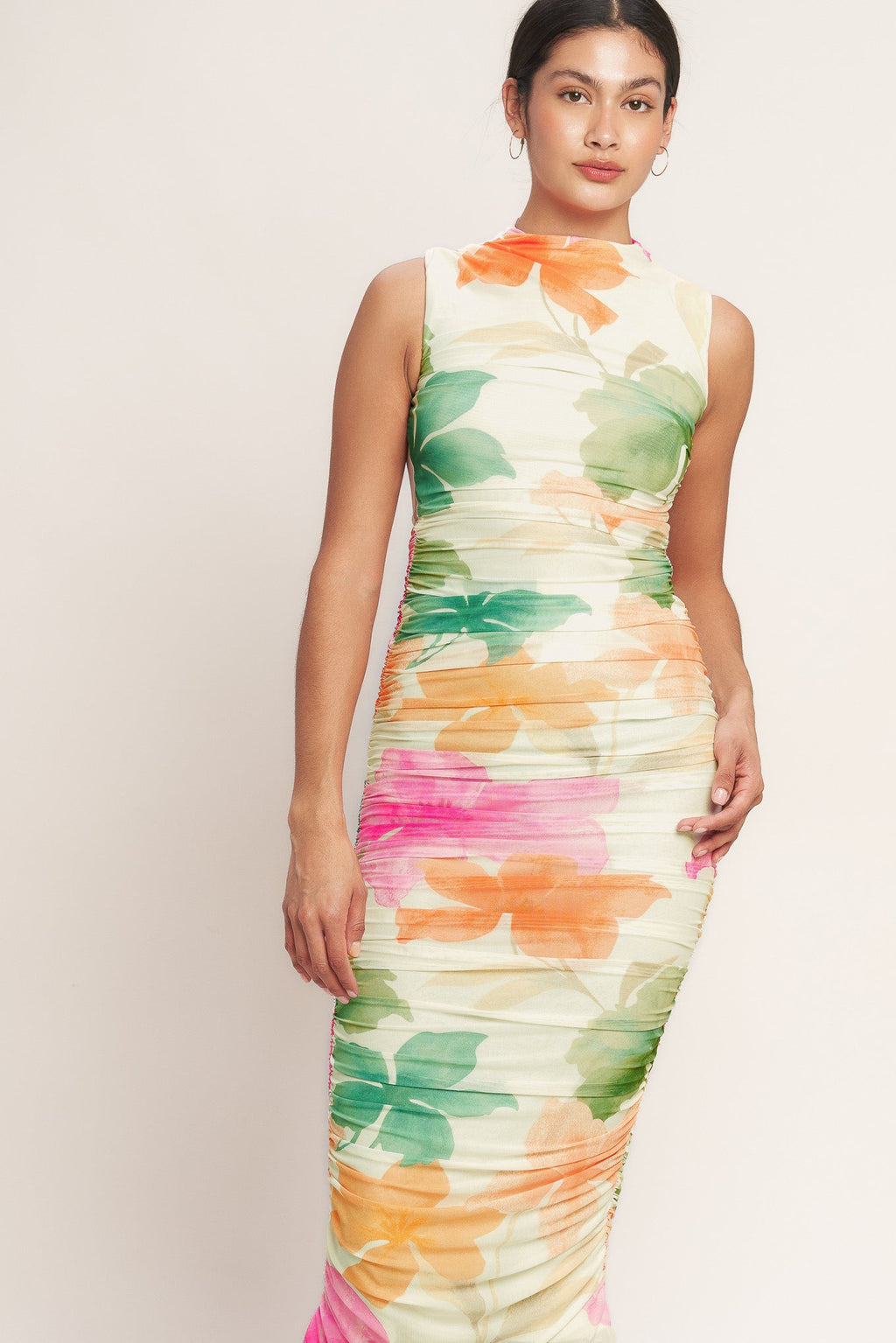 A colorful printed power mesh midi dress featuring tubular neckline, sleeveless, shirred side, body contouring and back zipper closure