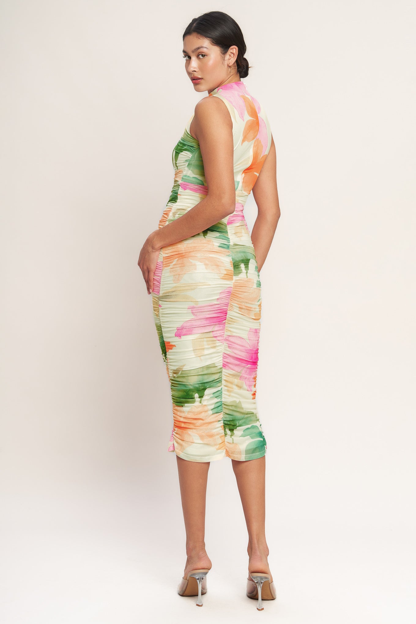 A colorful printed power mesh midi dress featuring tubular neckline, sleeveless, shirred side, body contouring and back zipper closure