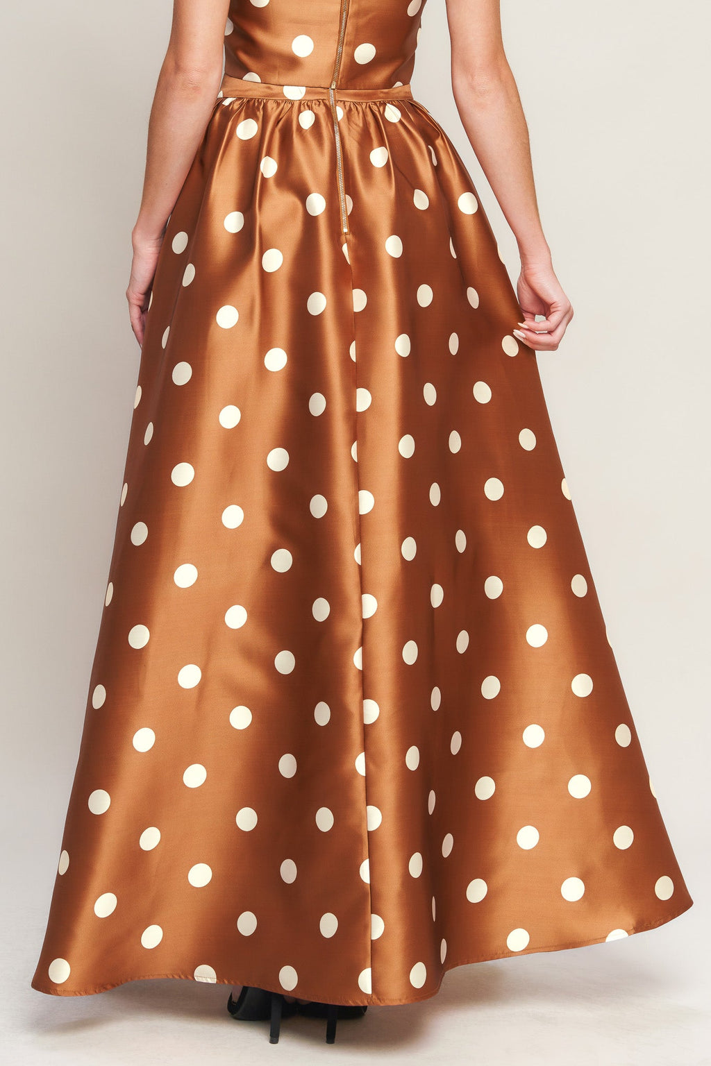 A polka dot printed woven full maxi skirt with size pocket and back zipper closure.
