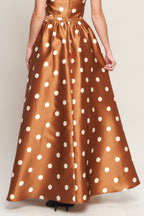 A polka dot printed woven full maxi skirt with size pocket and back zipper closure.