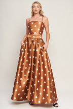 A polka dot printed woven full maxi skirt with size pocket and back zipper closure.
