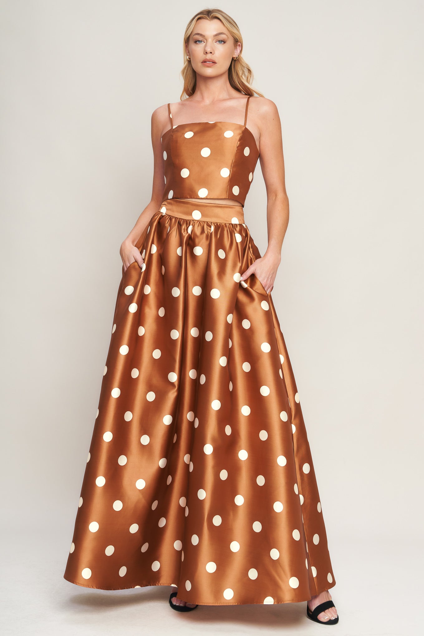 A polka dot printed woven full maxi skirt with size pocket and back zipper closure.