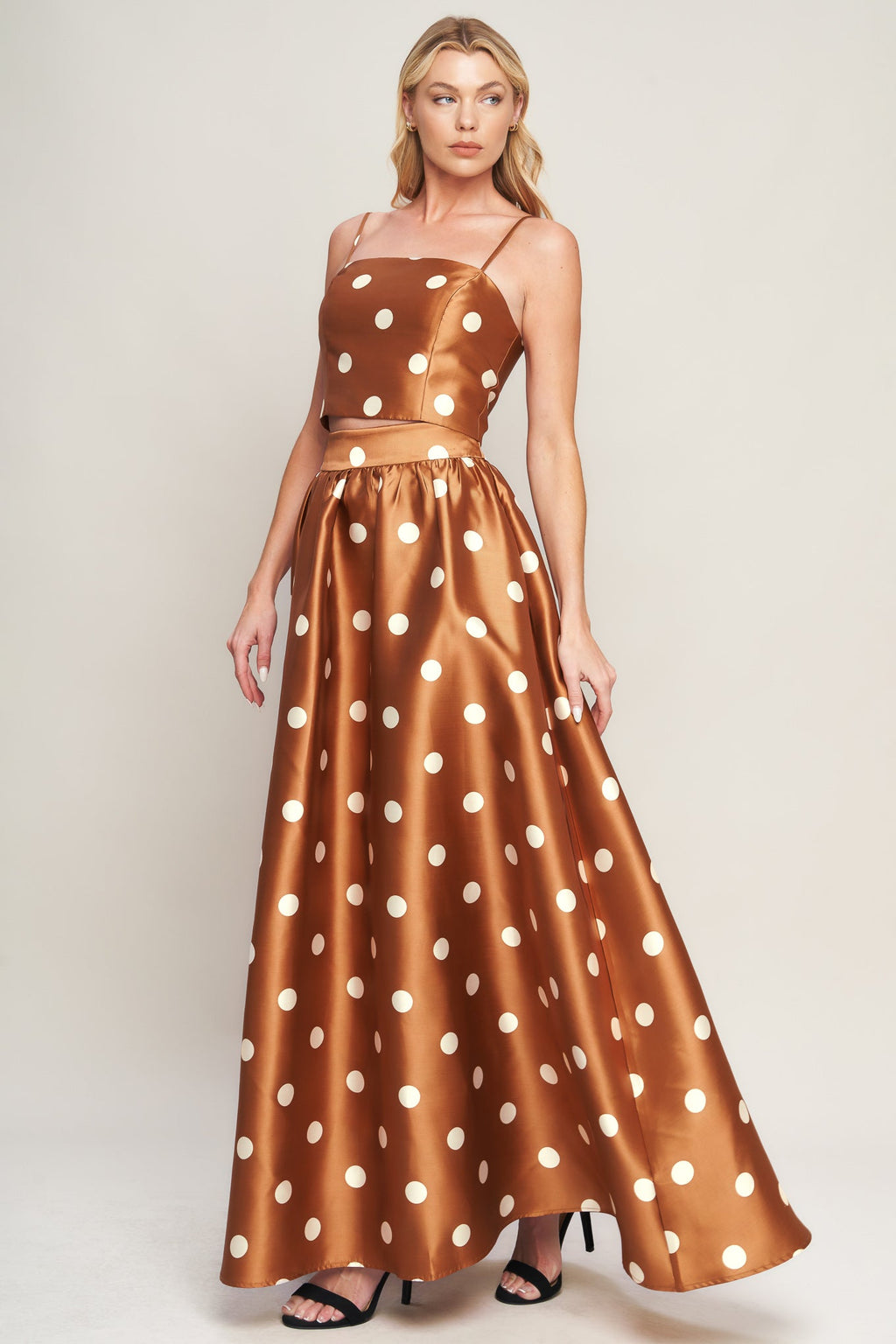 A polka dot printed woven full maxi skirt with size pocket and back zipper closure.