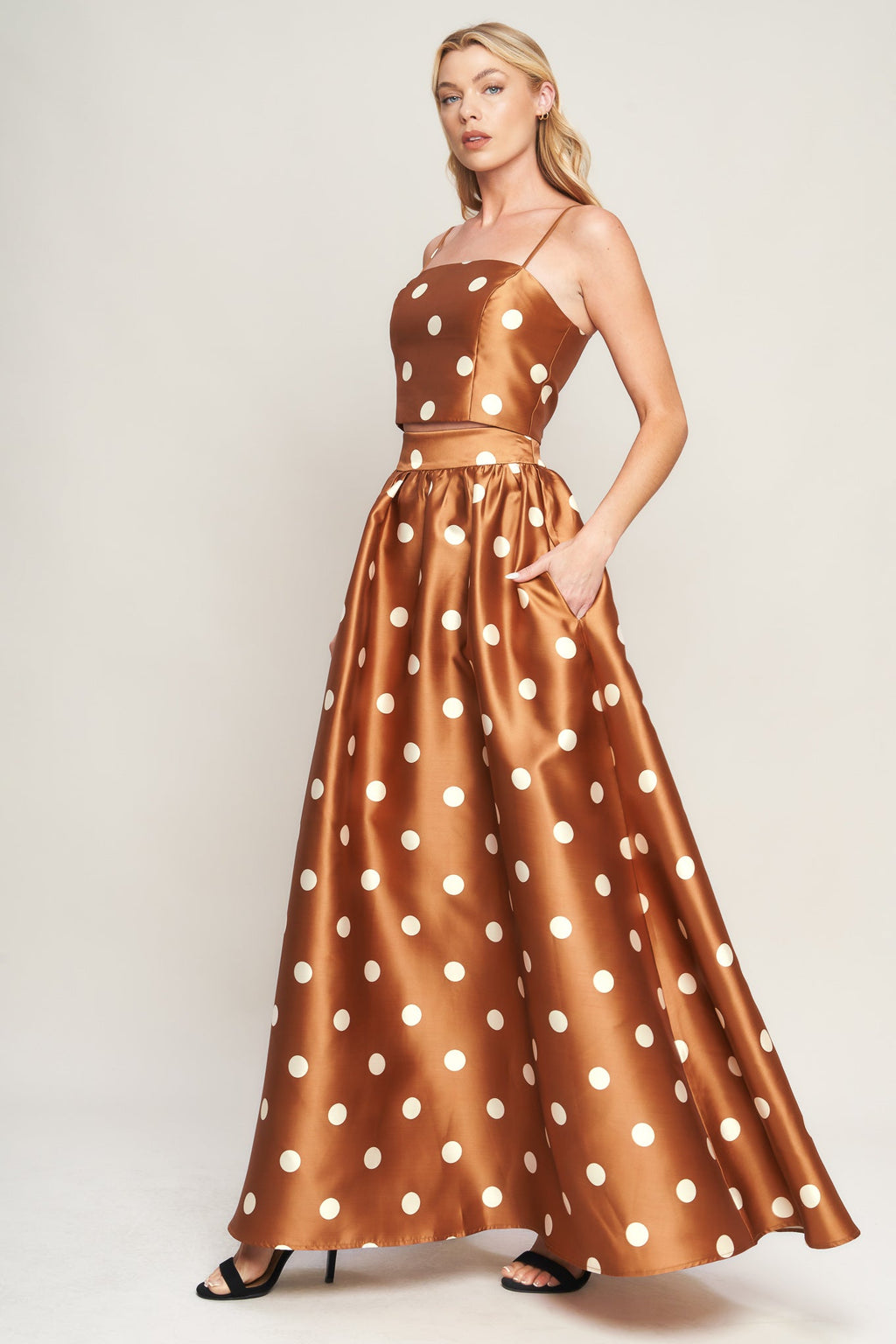 A polka dot printed woven full maxi skirt with size pocket and back zipper closure.