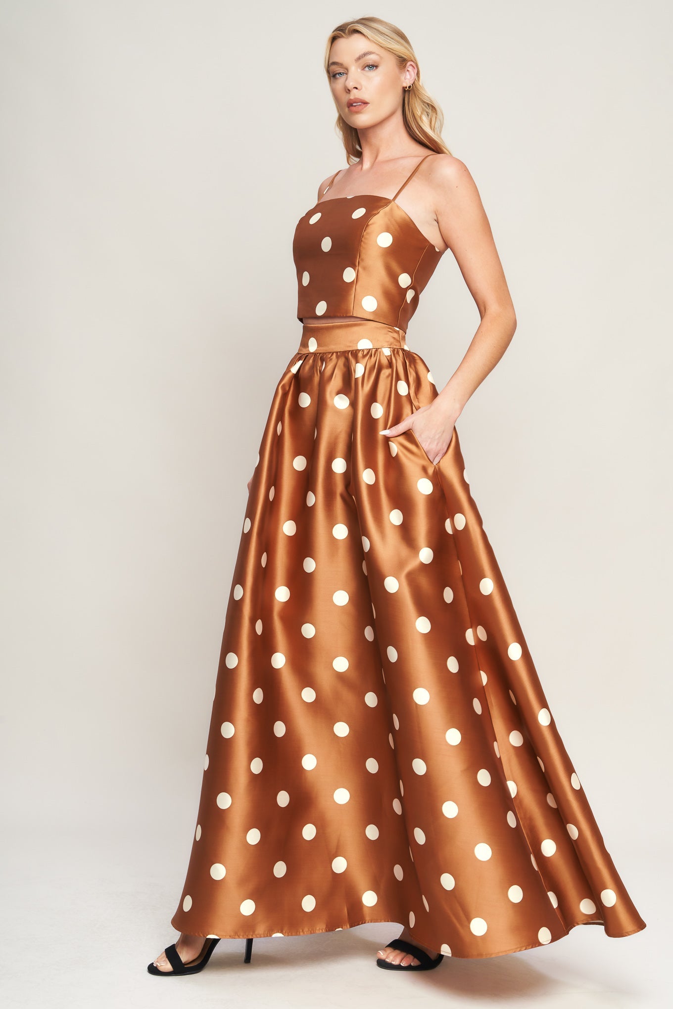 A polka dot printed woven full maxi skirt with size pocket and back zipper closure.