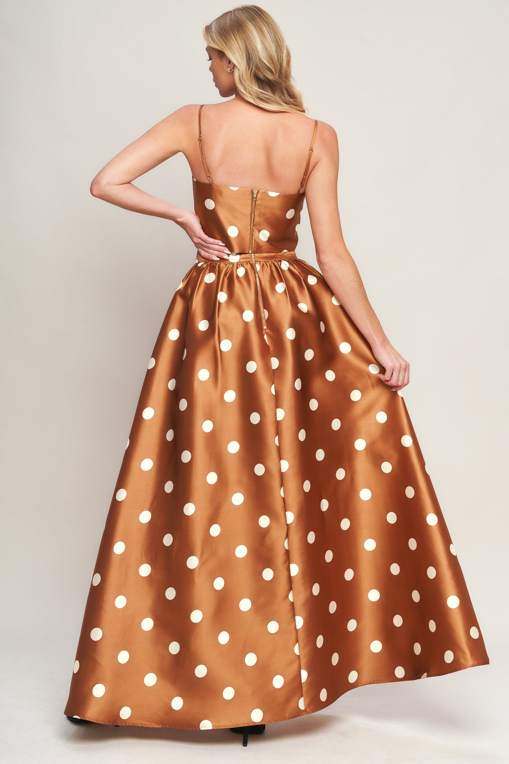 A polka dot printed woven full maxi skirt with size pocket and back zipper closure.