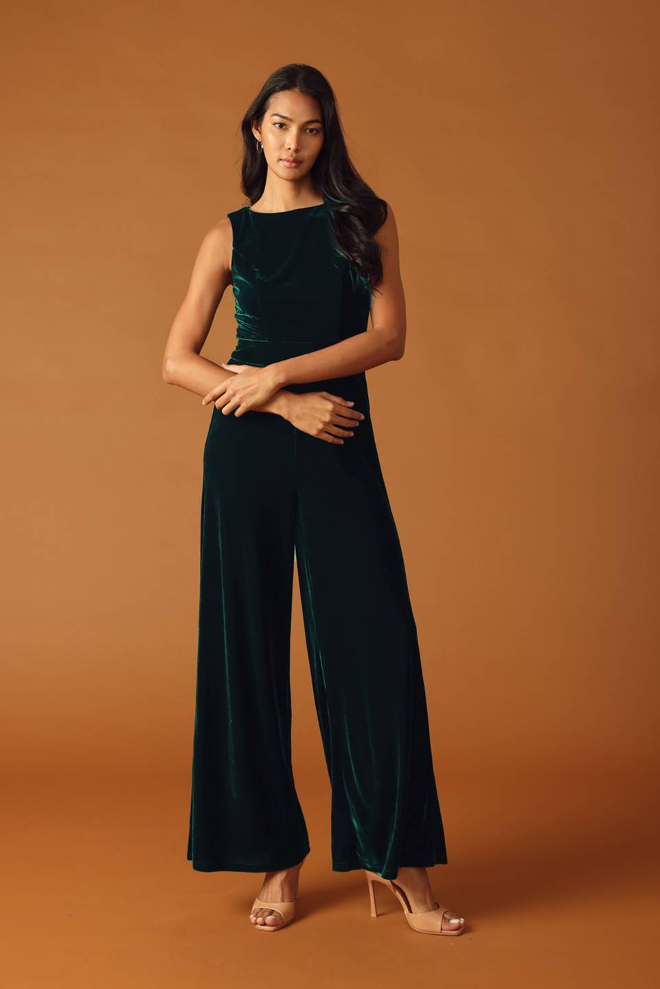 Woman wearing a green velvet jumpsuit 