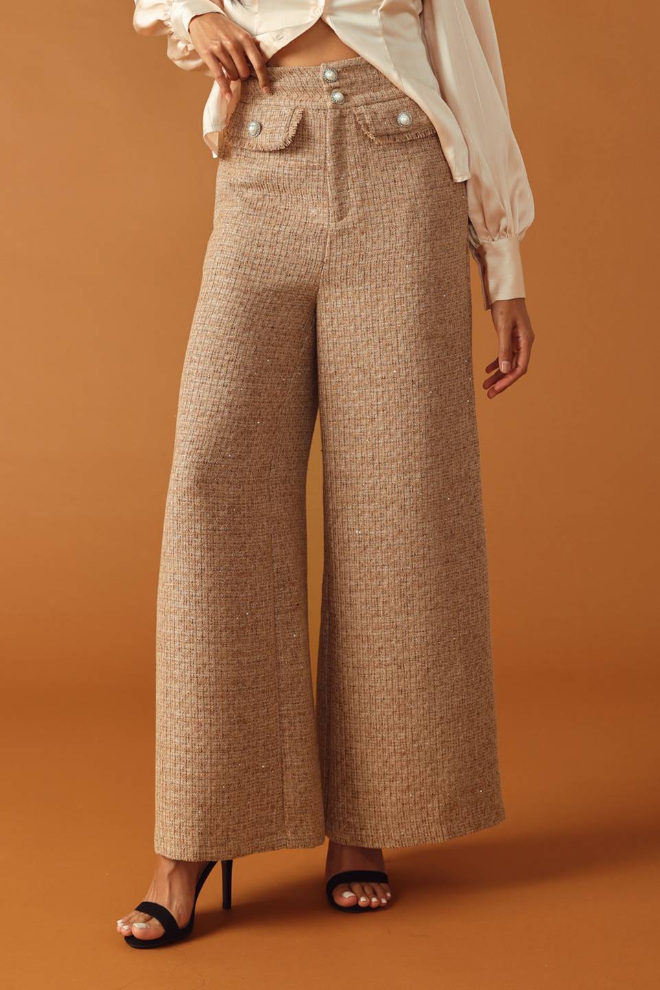 A tweed pant featuring front closure, jewel button and pockets