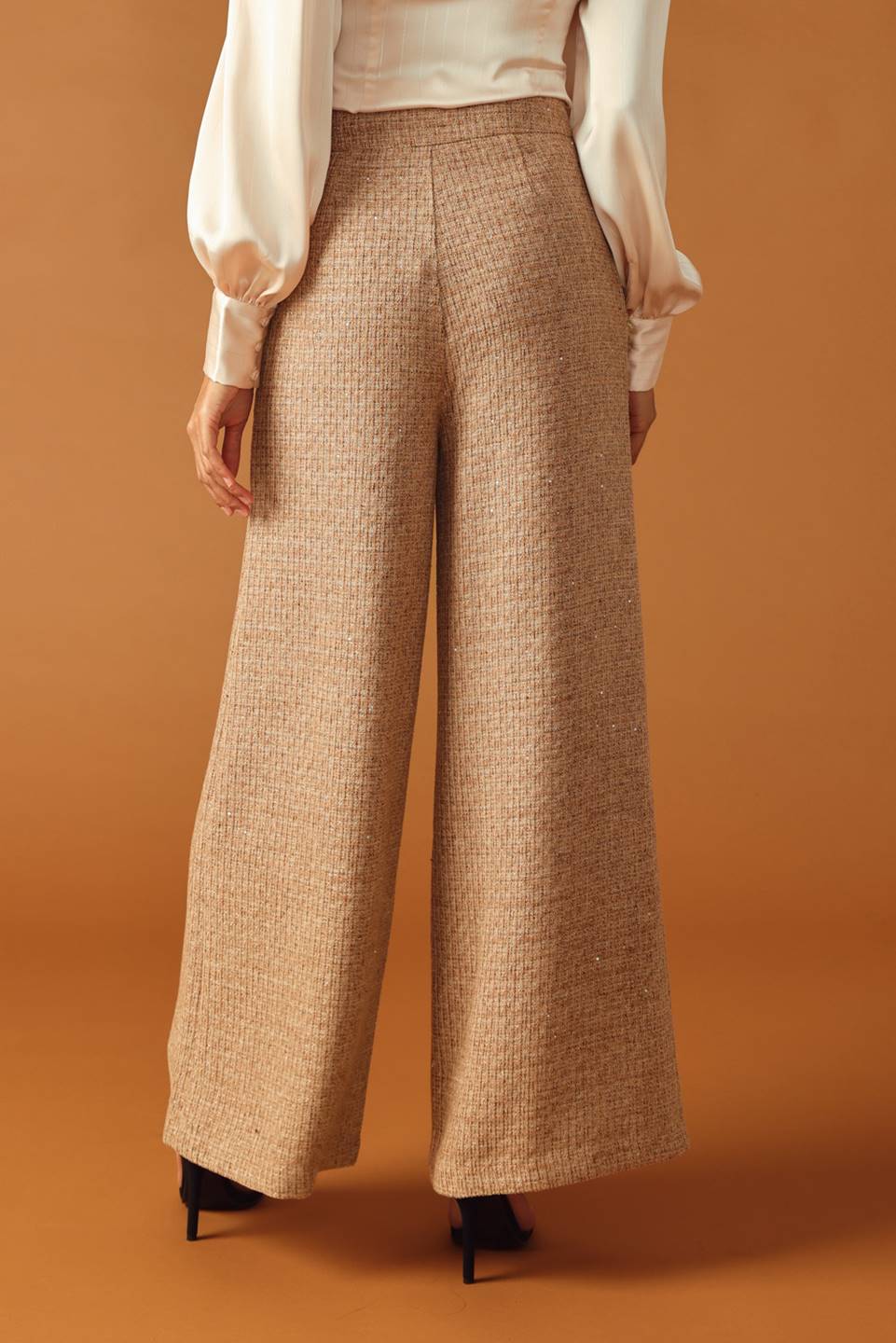 A tweed pant featuring front closure, jewel button and pockets