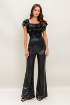 A black coated woven jumpsuit featuring off shoulder neckline, double layer pleated flounce, flare leg and back zipper closure