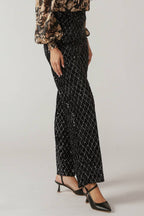 A black sequin pant featuring wide leg and side zipper closure.