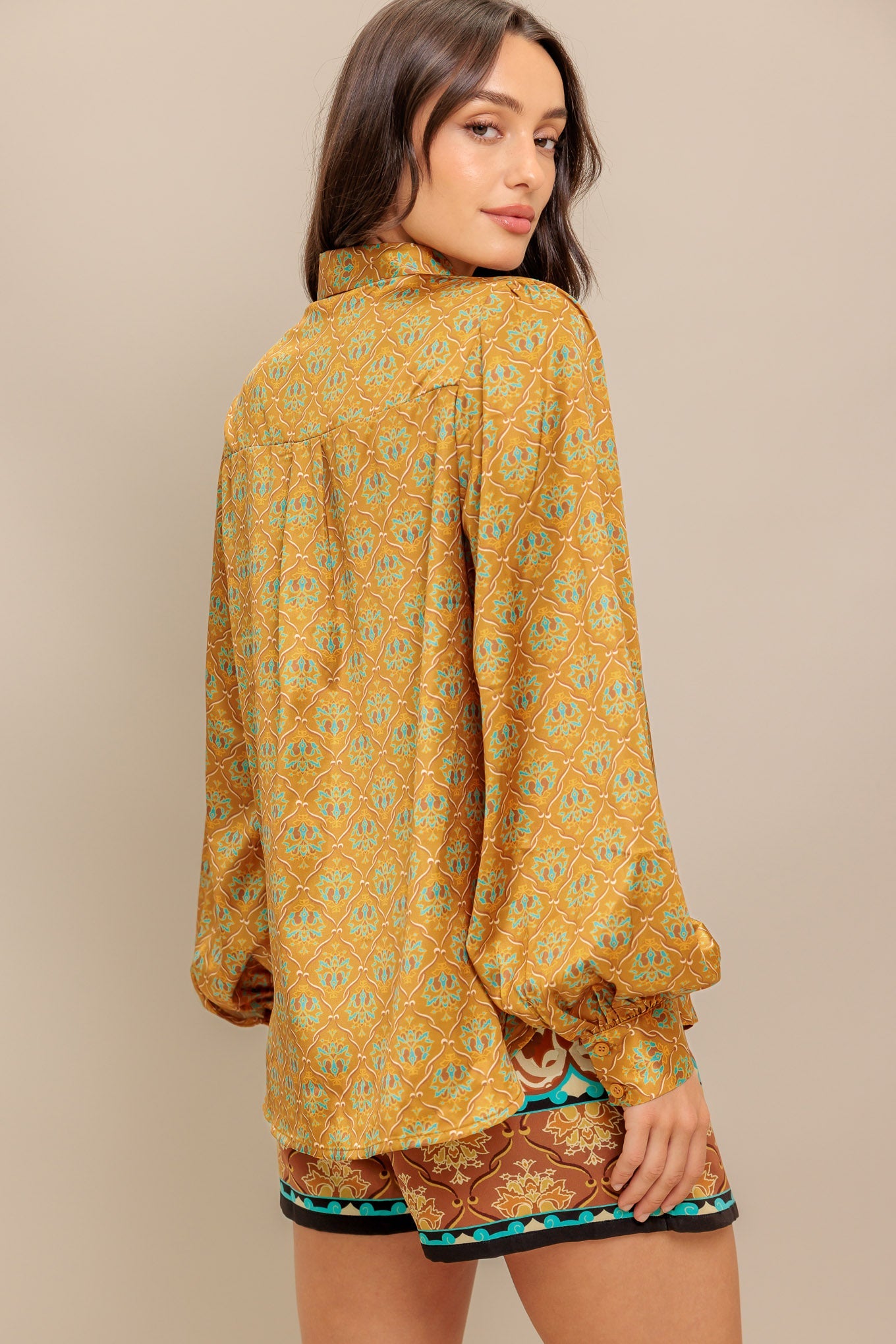 A printed woven top featuring collar, button down and long sleeve.