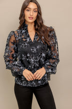 A woven organza top featuring high neckline with V center, long sleeve and cami