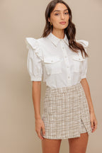 A solid white woven top featuring collar, snap button down, ruffled shoulder, short puff sleeve and pockets