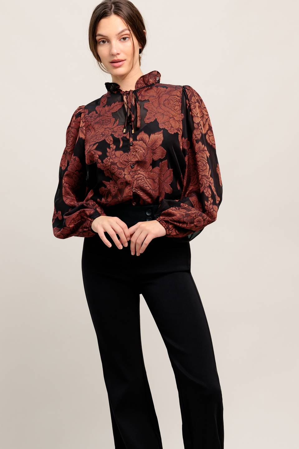 A jacquard woven top featuring ruffled neckline with front tie, button down and long sleeve