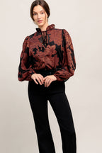 A jacquard woven top featuring ruffled neckline with front tie, button down and long sleeve