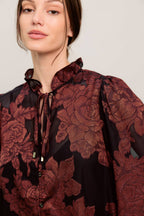 A jacquard woven top featuring ruffled neckline with front tie, button down and long sleeve