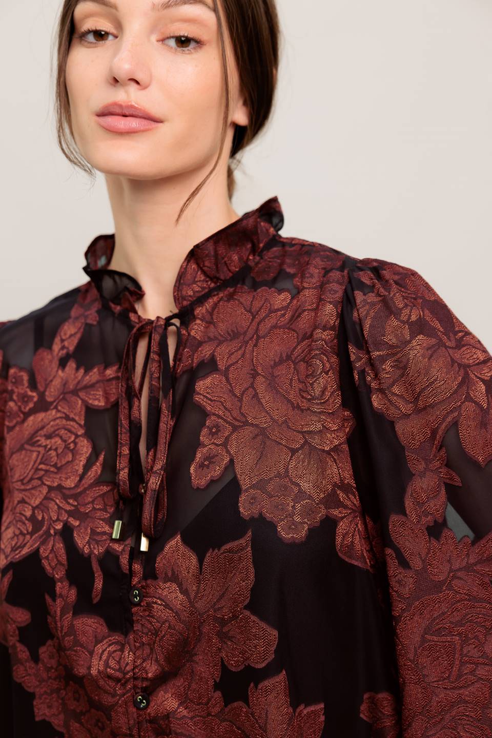 A jacquard woven top featuring ruffled neckline with front tie, button down and long sleeve