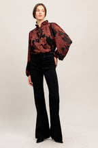 A jacquard woven top featuring ruffled neckline with front tie, button down and long sleeve