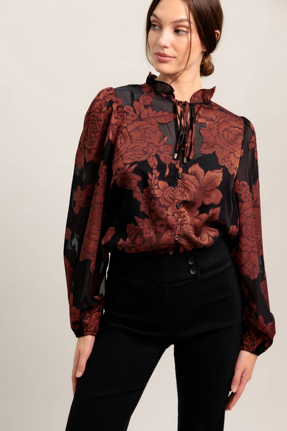 A jacquard woven top featuring ruffled neckline with front tie, button down and long sleeve