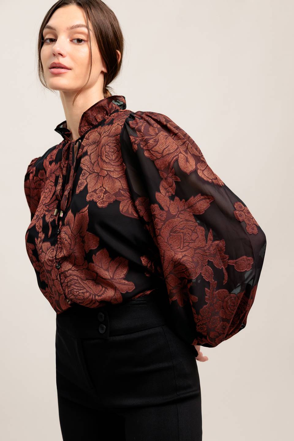 A jacquard woven top featuring ruffled neckline with front tie, button down and long sleeve
