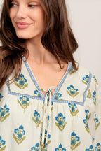 A printed woven top featuring V neckline with tie, yoke and long sleeve with smocked cuff