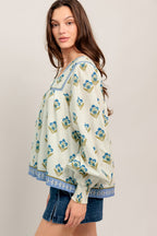 A printed woven top featuring V neckline with tie, yoke and long sleeve with smocked cuff