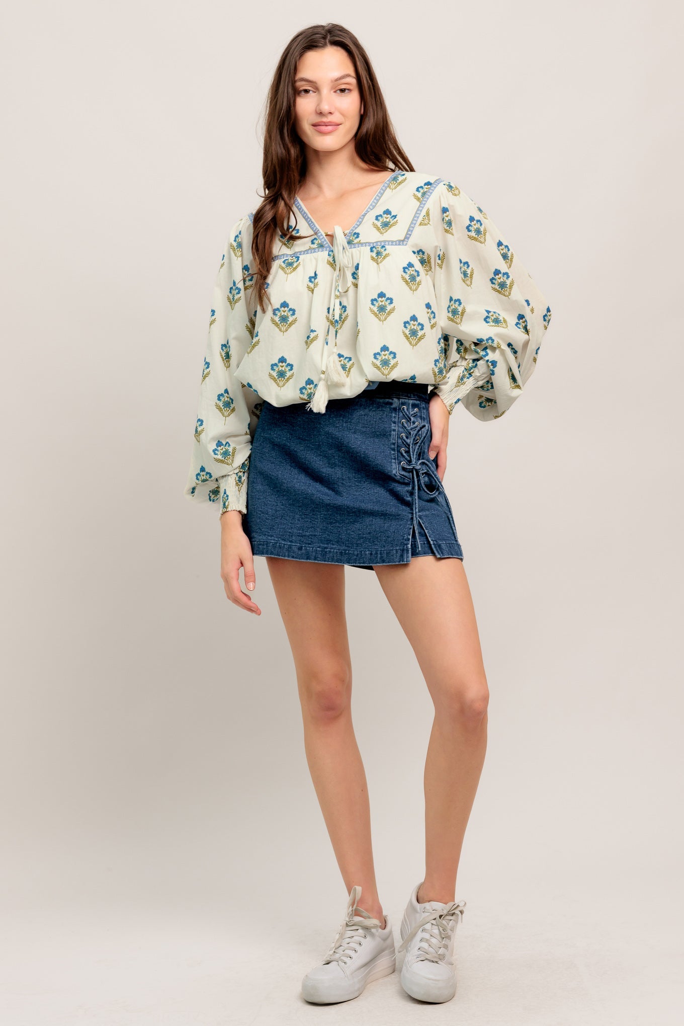 A printed woven top featuring V neckline with tie, yoke and long sleeve with smocked cuff