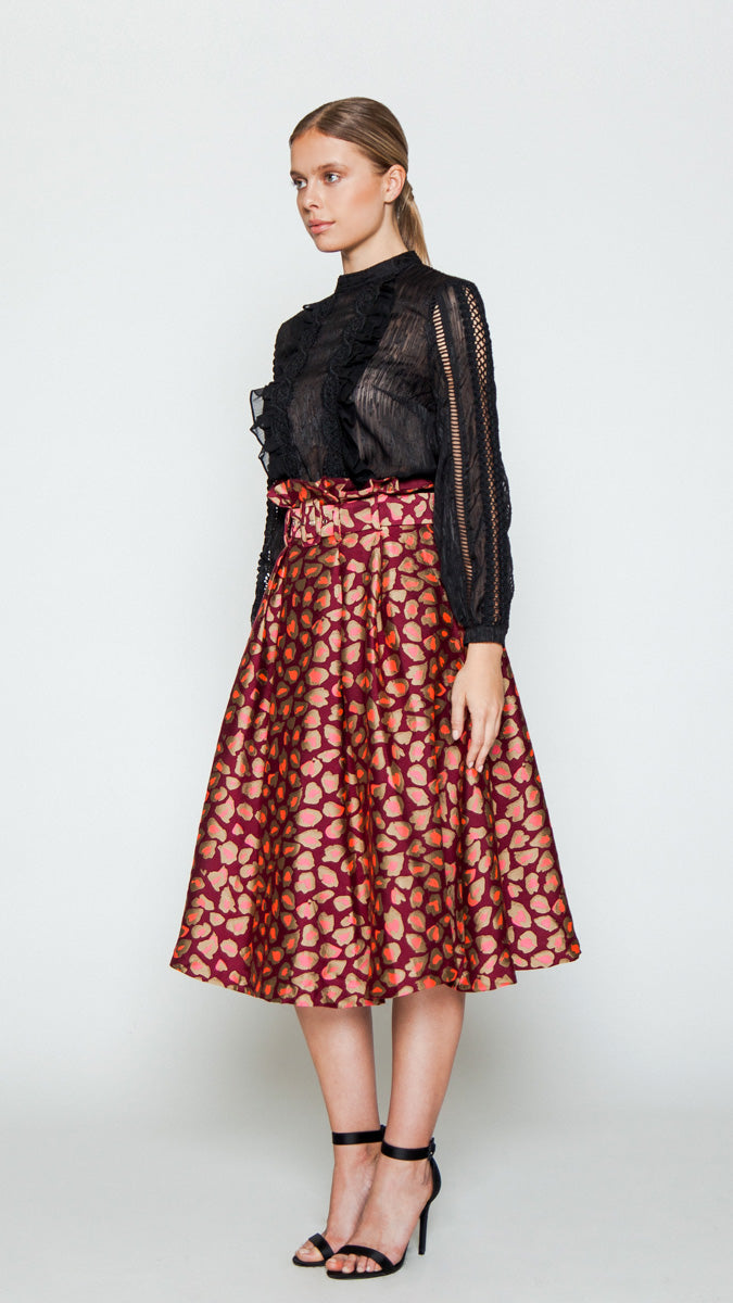 A midi skirt featuring an A-line silhouette, front and back pleats, high paper-bag waistline, side pockets, concealed back zipper closure, optional belt, lined skirt, and cheetah print design